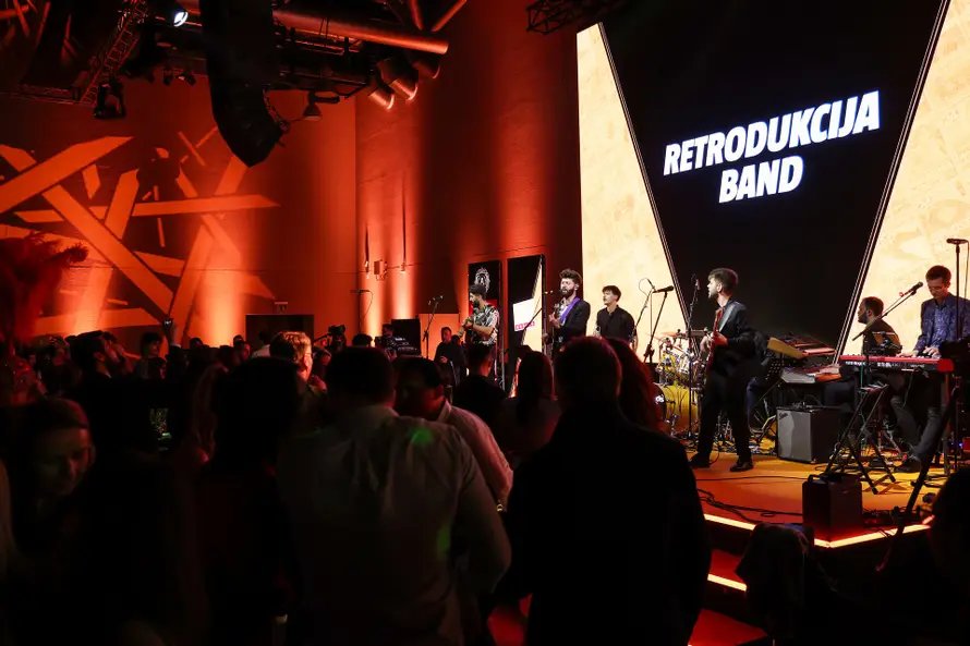 Retrodukcija na korporativnom eventu ispred LED pozadine s imenom benda
