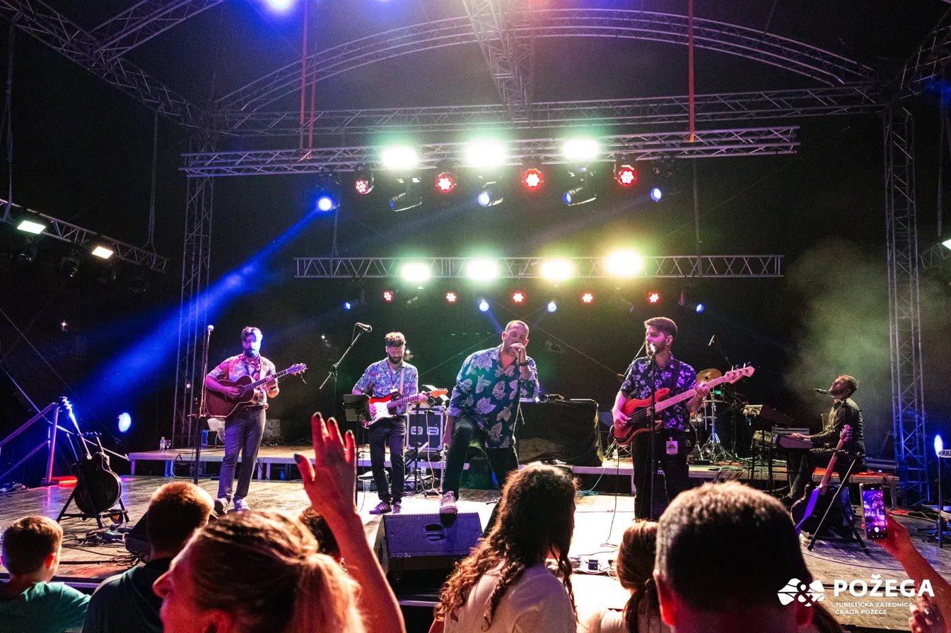 Retrodukcija na festivalskoj pozornici, publika s podignutim rukama